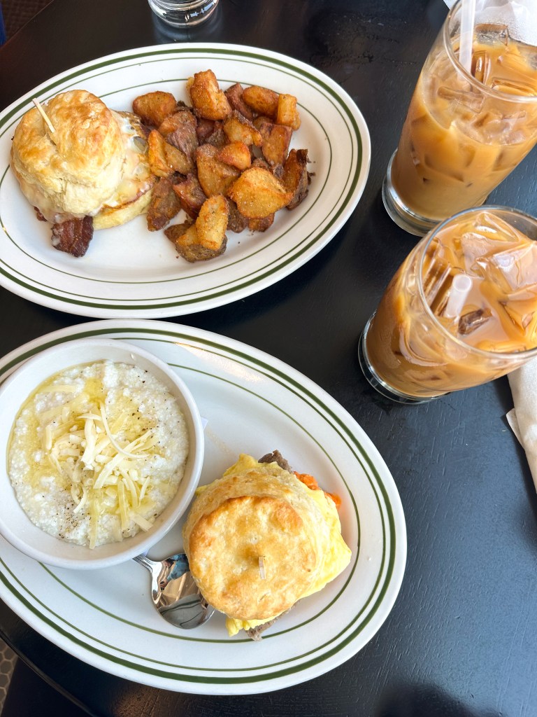 2 biscuit sandwiches, a side of crispy potatoes, a side of cheesy grits & 2 iced coffees